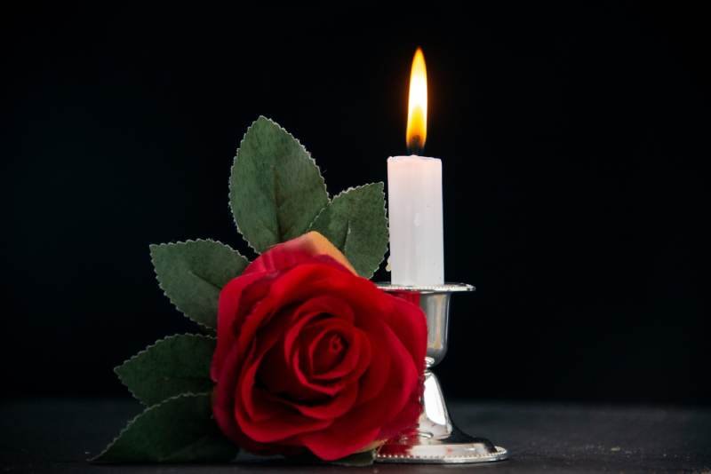 Burning candle with red flower